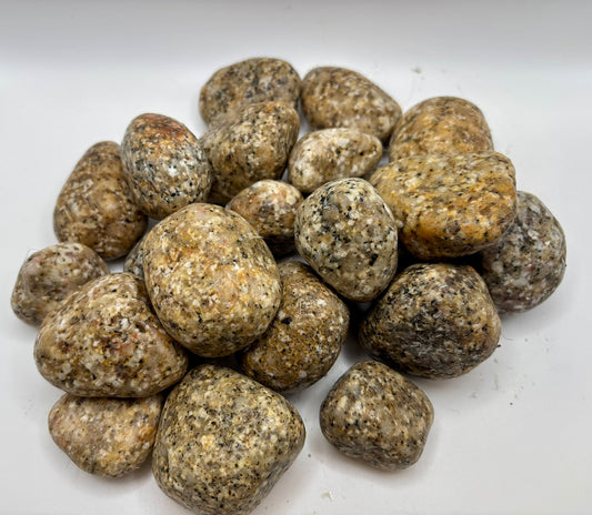 Pile of round, Gold and Black Granite stones on a white background