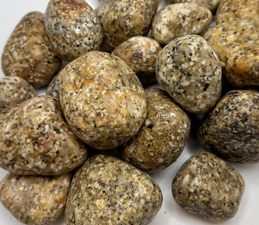 Pile of round, Gold and Black Granite stones on a white background