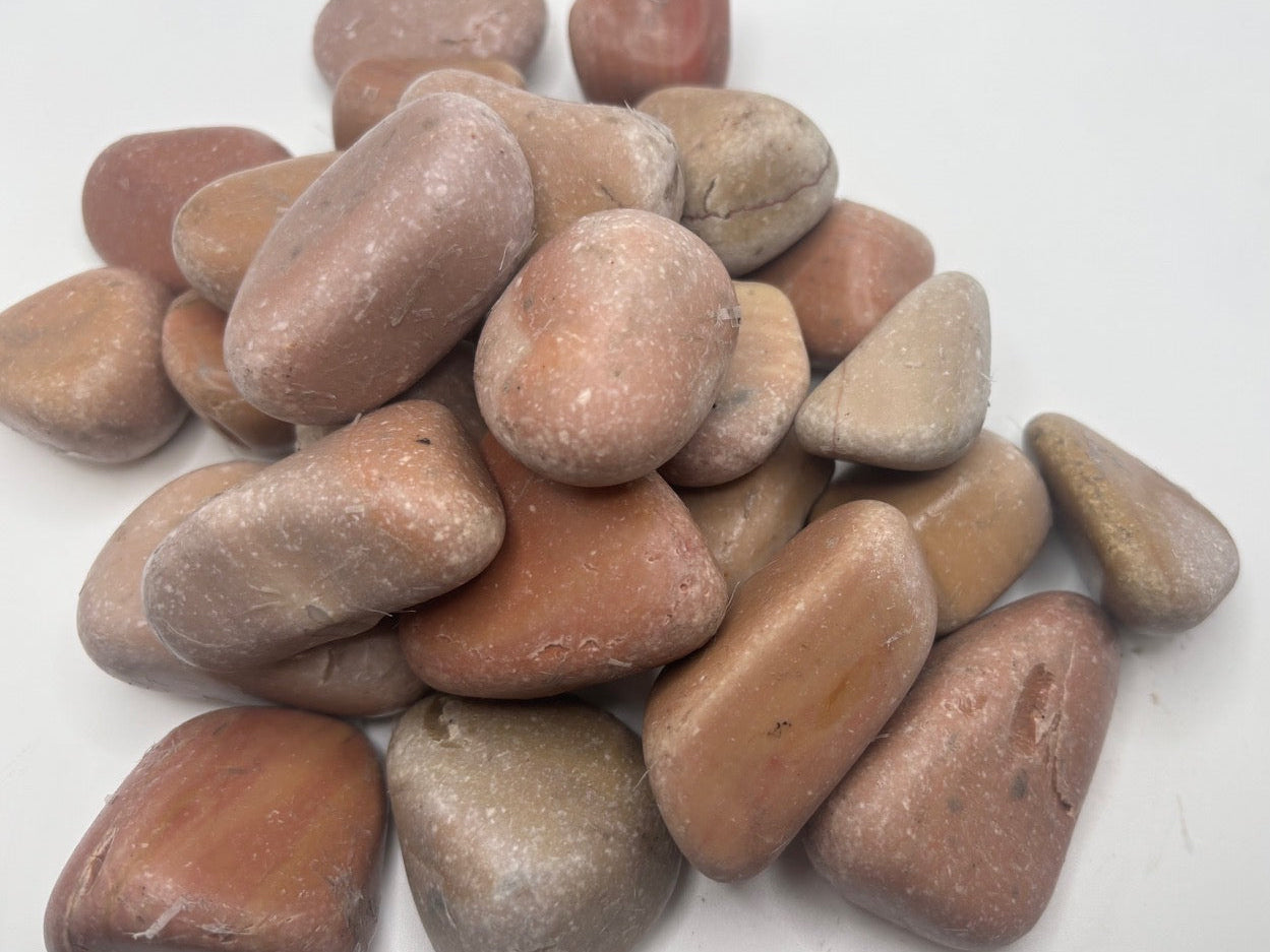 Pile of mauve and pink stones on a white background